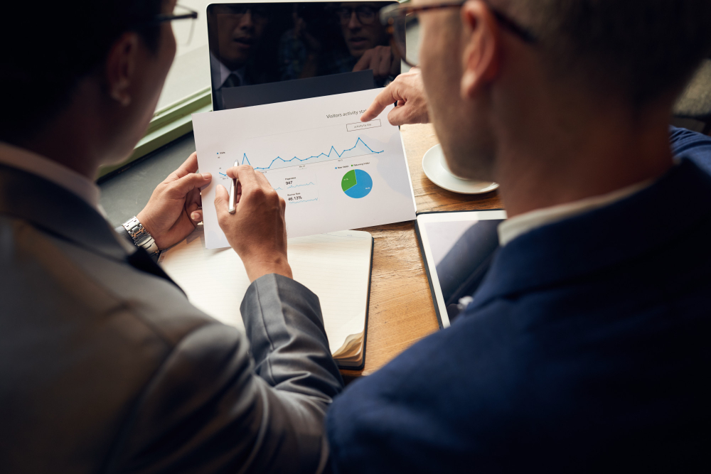 The men in the image are studying the graphs and tracking the KPIs and Metrics