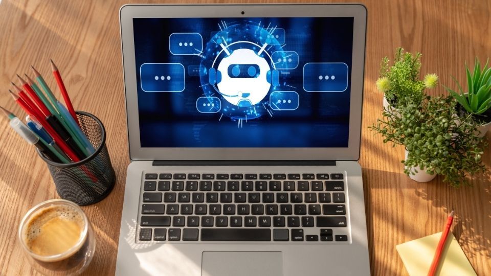 (In the image a chatbot can be seen working on a laptop handling some services) Chatbot development services