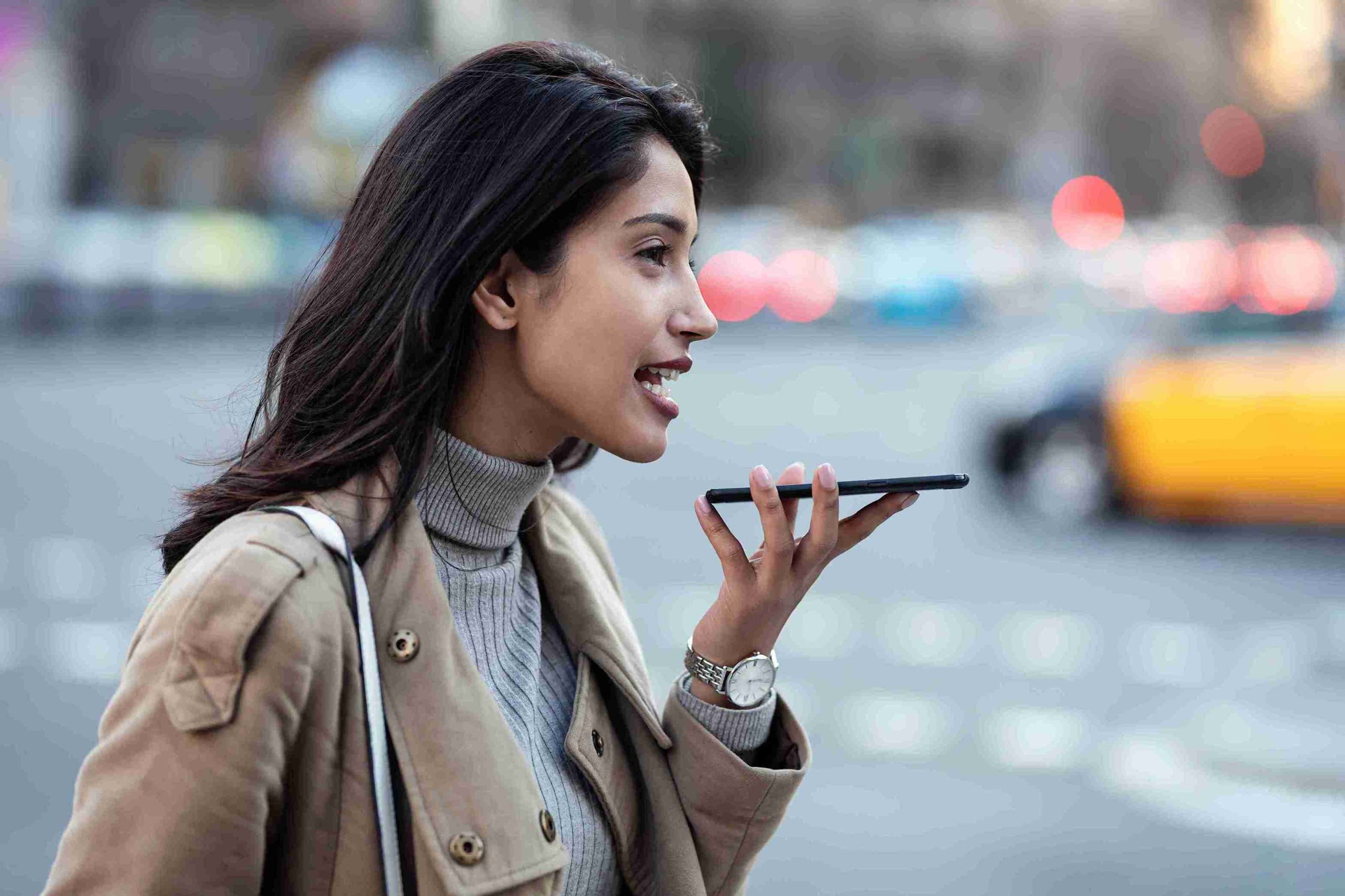 woman-on-city-street-using-voice-assistant