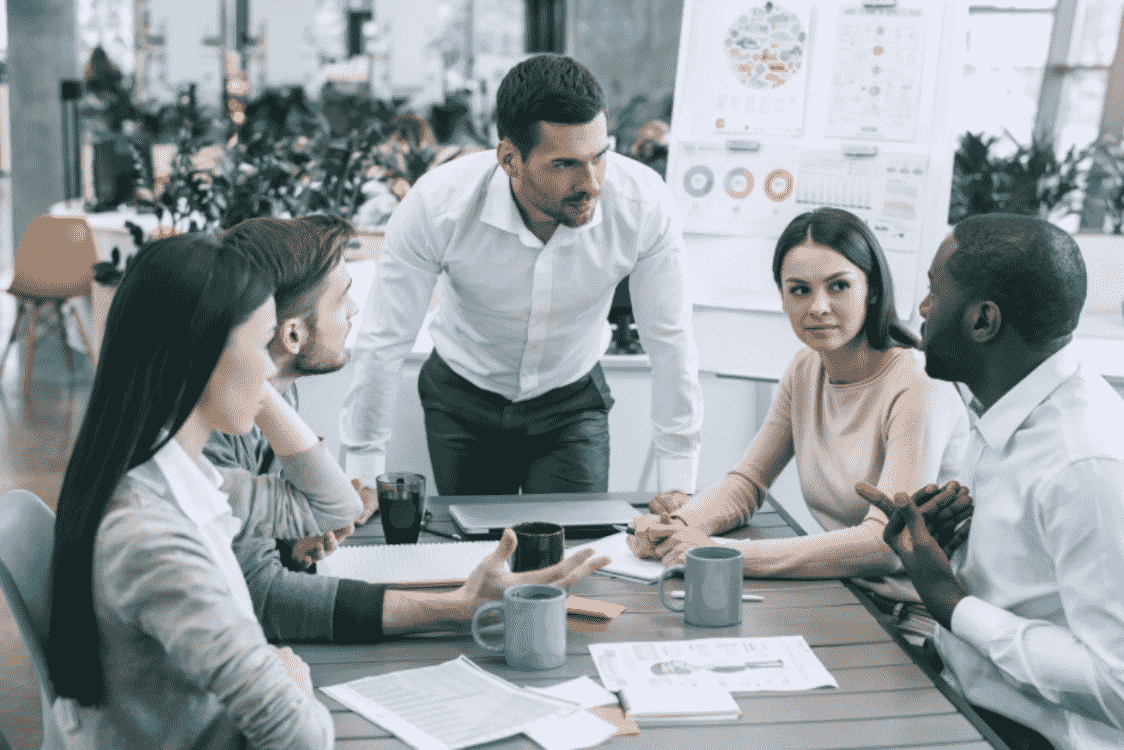 A diverse business team discussing strategy around a table, representing the alignment needed to implement effective behavioural targeting campaigns.