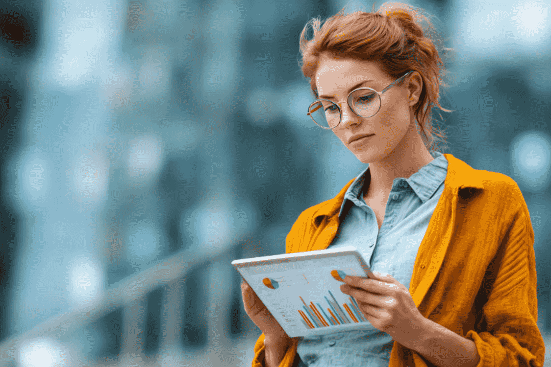 A focused woman reviewing data charts on a tablet, symbolizing the use of analysis and behavioural market segmentation insights