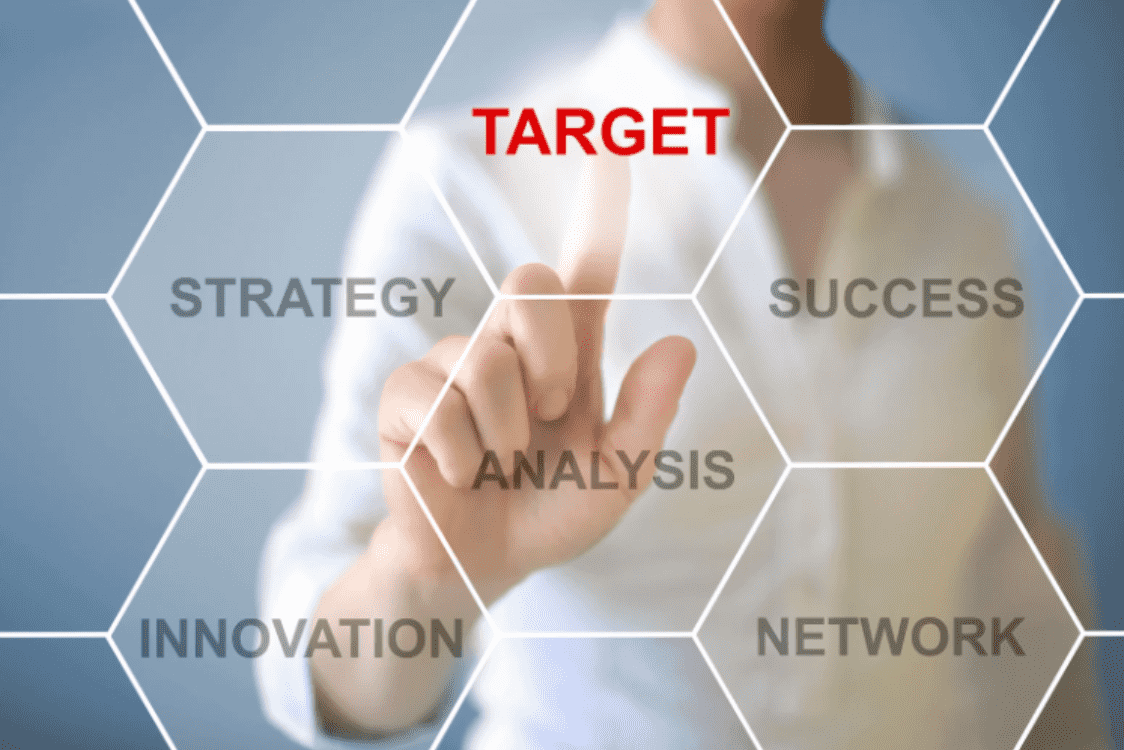 A hand touches a screen with the word TARGET at the center of a hexagon graphic, illustrating strategy and the precision of behavioural targeting A hand touches a screen with the word TARGET at the center of a hexagon graphic, illustrating strategy and the precision of behavioural targeting
