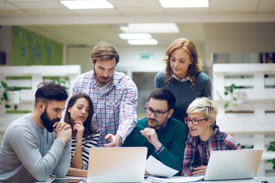 (A professional team reviewing website performance and user-interface design on a laptop.)