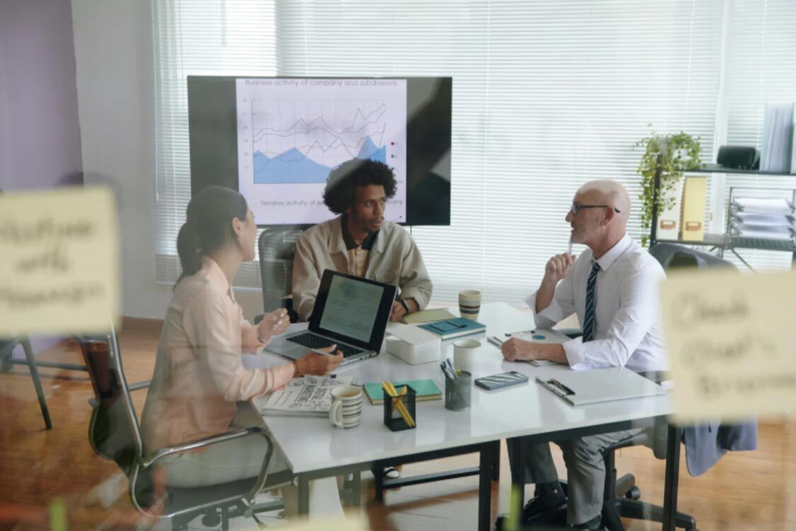 (Professional marketers discussing data-driven insights and neuromarketing psychology during a strategy meeting in a modern office.) neuromarketing tactics