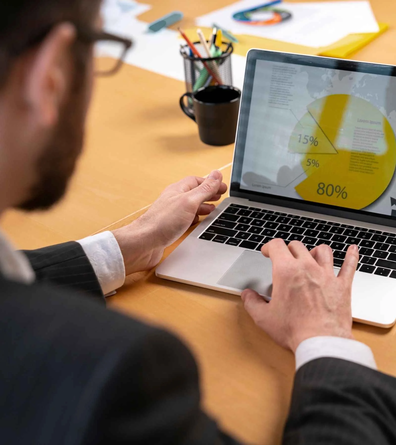 Man viewing a pie chart on a laptop.
